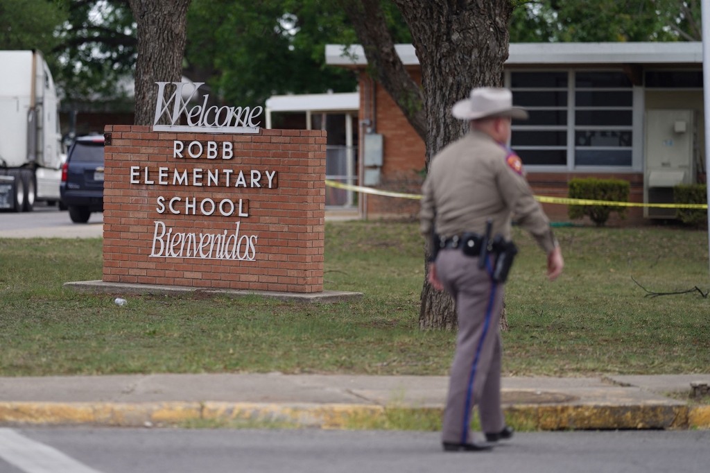 A police officer at Robb Elementary School in Uvalde, Texas where 21 people were killed in a mass shooting.